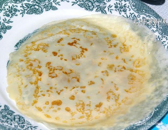 Блинчик лежит на тарелке и хорошо видно, как просвечивается рисунок.