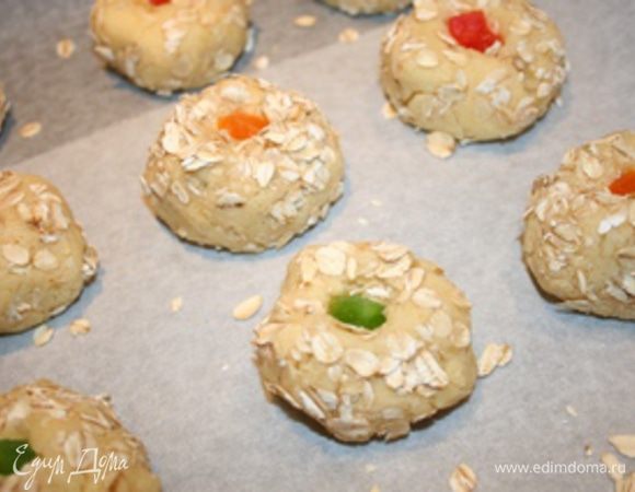 Цукаты залить кипятком, дать настояться 10 минут. Разогреть духовку до 180°C. В центр каждого печенья положить цукаты и слегка прижать пальцами. Выпекать 20 минут. Приятного чаепития!