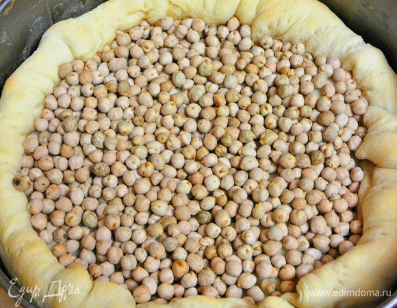 Тесто раскатать в круг диаметром 28см.Выложить в форму диаметром 24-26см.Боковым краям придать форму бортиков.Тесто наколоть часто вилкой,наполнить горохом или фасолью.Поставить выпекаться в заранее разогретую духовку до 180гр.примерно минут на 15.