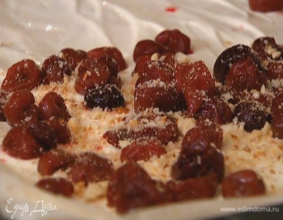 Не смазывая последний слой фило маслом, равномерно распределить по нему начинку из сливочного сыра, затем на одну половину теста выложить вишню, посыпать миндальной крошкой и свернуть рулет, начиная с того края, где находится вишня.