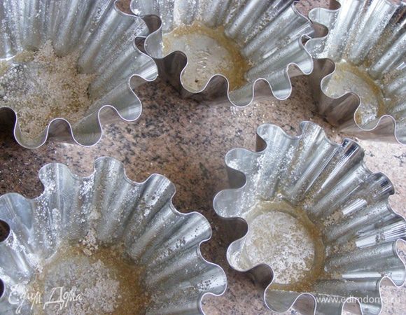 Формочки смажем маслом и обсыпем молотыми овсяными хлопьями