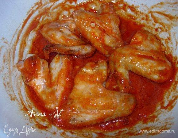  Смешайте в большой миске чесночное масло с острым соусом и солью. Поместите туда готовые крылья, перемешайте.