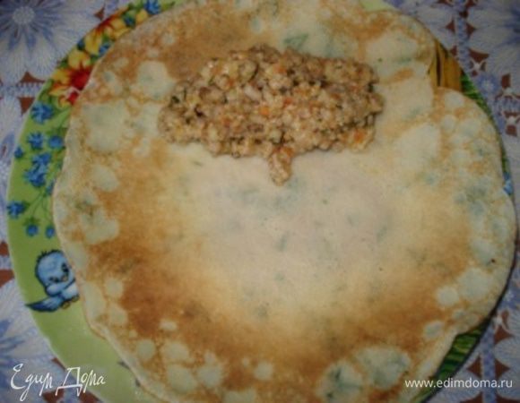 Блин выкладываем поджаренной стороной вверх. Выкладываем начинку и заворачиваем блинчики рулетом.