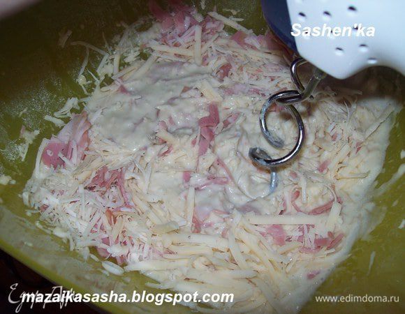 Постепенно ввсети в тесто винно - маслянную смесь. Перемешать до однородной массы. Добавить сыр и ветчину и быстро перемешать.