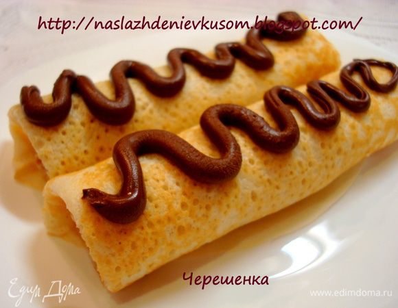 Украсить вы можете на свое усмотрение. У меня, честно говоря, время было ограничено, поэтому я быстренько положила шоколад в СВЧ на полную мощность на 2 минуты, затем выложила его в обыкновенный пакетик, сделала в нем зубочисткой дырочку и выдавила на блинчики… Вот такая прелесть получилась…