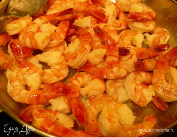 В большой сковороде разогреваем сливочное масло и обжариваем креветки пару минут, солим, перчим. У меня они выделили воду, которую я слила. Теперь будем их фламбировать. Сначала напишу, как делала я. В небольшой кастрюльке подогреваем Куантро, затем поджигаем его (у меня это делал муж) и поливаем им наши креветки (я их на это время сняла с плиты). Все это очень красиво горит, у меня горело несильно. Пока горит немного их перемешиваем. Когда пламя пропало, можно возвращать креветки на огонь. В оригинале предлагалось Куантро добавить в сковороду к креветкам и поджечь. Так что выбирайте удобный для Вас способ.
