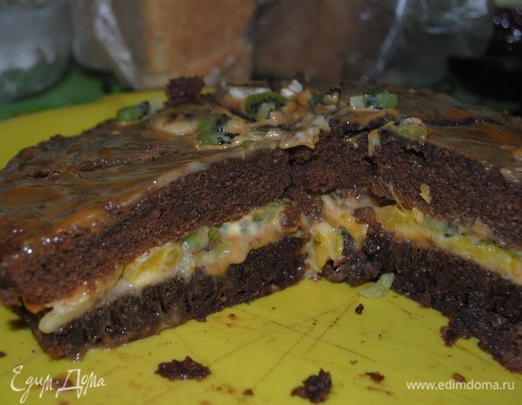 Сливочное масло и кусочки шоколада растопить в микроволновой печи в течении 2 минут.100г сахара взбить с 3 яйцами, добавить муку, разрыхлитель, коньяк и растопленные шоколад и масло.Хорошо вымешать тесто.Выпекать в микроволновой печи в термостойкой посуде в течении 7 минут(или в обычной духовке). Пока бисквит печется делаем крем-1 яйцо взбиваем с сахарной пудрой, вымешиваем с мягким сливочным маслом и добавляем или ваниль, или растопленный шоколад, в зависимости от того,какой крем мы хотим приготовить. Бисквиту даем остыть,разрезаем его поперек на 4-5 частей, смазываем кремом,укладываем фрукты и обсыпаем шоколадной крошкой. Приятного аппетита!