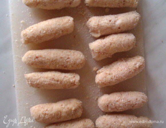 Отделяем от " куриного теста " небольшую котлетку, валяем её в муке, затем в яйцах, потом в панировке. После формируем как угодно: шариком, палочками или ромбиками.
У меня получилось вот так:
