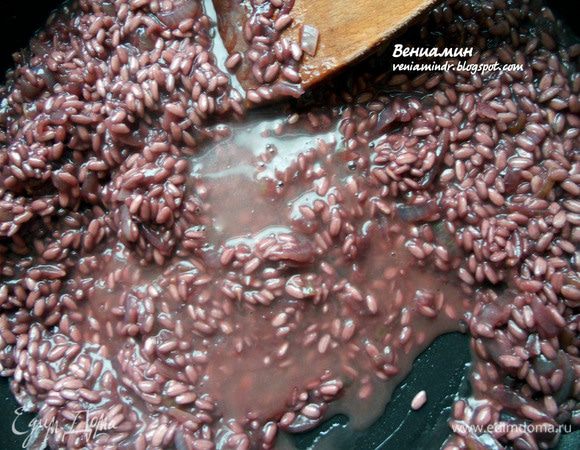 Огонь уменьшить. Добавить примерно половник (или чуть меньше) бульона, оставить на несколько минут, пока жидкость практически полностью не впитается, помешивая. И так повторять процедуру до готовности риса, примерно 20-25 минут (переваривать нельзя, должен оставаться al dente). Что касается оставшейся части вина, по рецепту полагалось влить его в самом конце, вместо последнего половника бульона и хорошо выпарить. Я поступил иначе: чередовал его с бульоном, хотя это и не совсем правильный подход (в процессе приготовления не желательно использовать холодные жидкости). Однако мне  показалось, что таким способом удастся сохранить насыщенный цвет ризотто, а самое главное - не будет резкого алкогольного запаха. В принципе ничего криминального не произошло, напротив, у ризотто была привильная консистенция. 