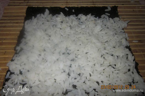 Отварить рис,добавить в него специальный уксус для суши.Лист нори разложить на циновке блестящей стороной вниз.Выложить рис.