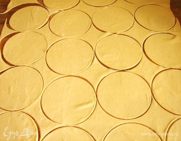 Слоённое тесто раскатать,как можно тоньше.Выемкой или стаканом вырезать круги.