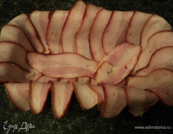 Шпик нарезать тонкими длинными полосками и выложить ими дно и бока металлической формы.