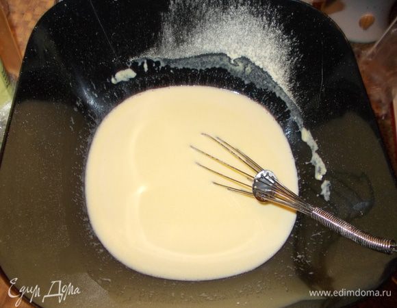 В тесто добавить соду. Затем влить яично-молочную смесь и перемешать. 