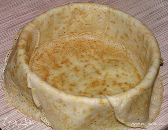 Половину испеченных блинчиков уложить в разъемную форму для выпечки так, чтобы свисали края. Поверх уложенных блинчиков положить еще один блин на дно формы (у меня диаметр формы 18 см).