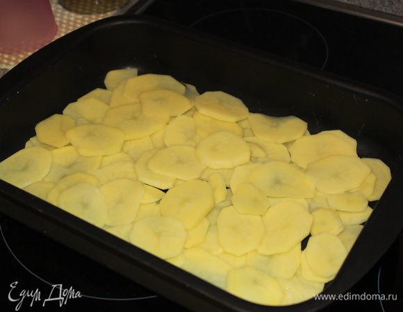 Картофель почистить, нарезать кружочками и выложить половину картофеля в форму для запекания , немного посолить.