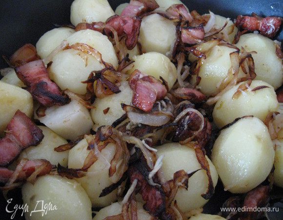 Готовую картошку сцеживаем, перекладываем в сковороду с беконом и луком, крошим чеснок, аккуратно перемешиваем.