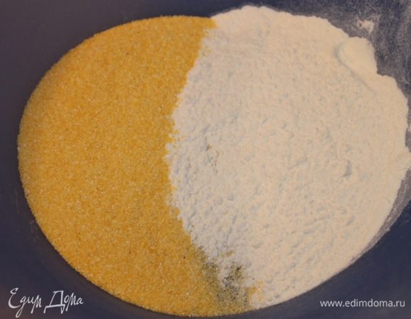 Смешаем в большой миске пшеничную и кукурузную муки, дрожжи, теплую воду, соль, сахар, оливковое масло. Помешаем до однородности. Затем добавим еще немного белой муки и месим тесто несколько минут. Если нужно добавим еще немного белой муки. Тесто не должно приставать к рукам. 