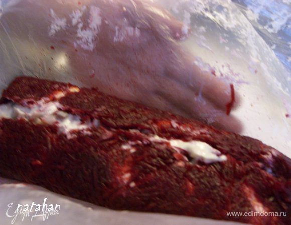 Начинаем самое главное - сворачивать рулет: поднять целлофан с широких сторон прямоугольника и, помогая руками за целлофаном, соединить широкие стороны в середине.