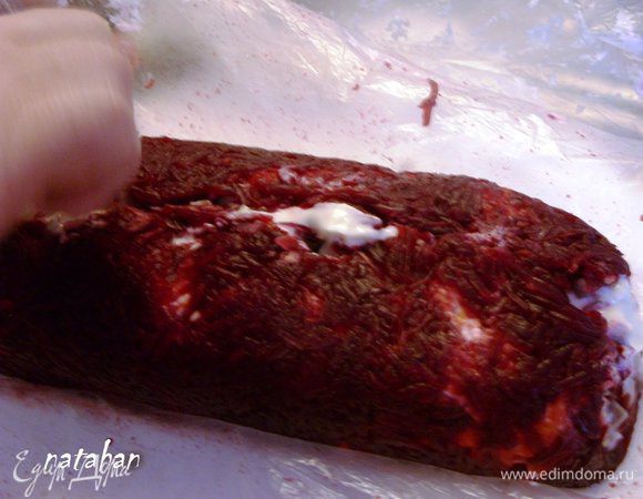 Освободить рулет от целлофана сверху и аккуратно соединить свекольные  границы.   