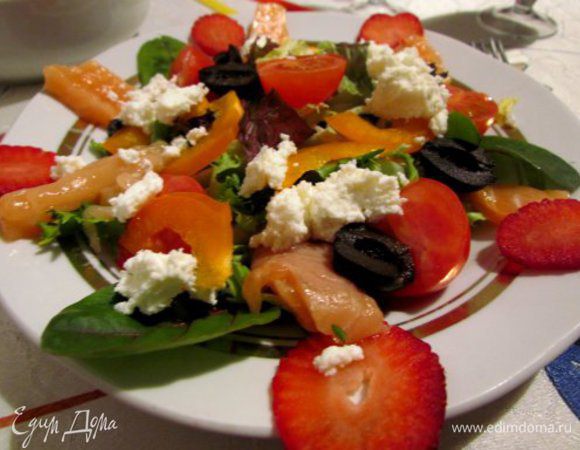 На плоской тарелке выложить листья салата, порезанную на тонкие ломтики семгу, половинки помидоров чери, половинки маслин, кусочки перца, творожный сыр. Украсить по краям тарелки ломтиками клубники.