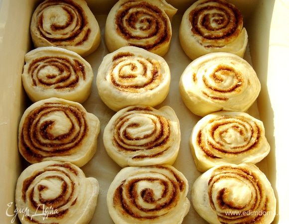 Скатать тесто в рулет по узкой стороне прямоугольника,немного оттягивая тесто.Разрезать на кусочки 3-4 см. Выложить в форму (26х26 см),оставляя между булками достаточное расстояние. Выпекать при t 200*С около 30 минут. 