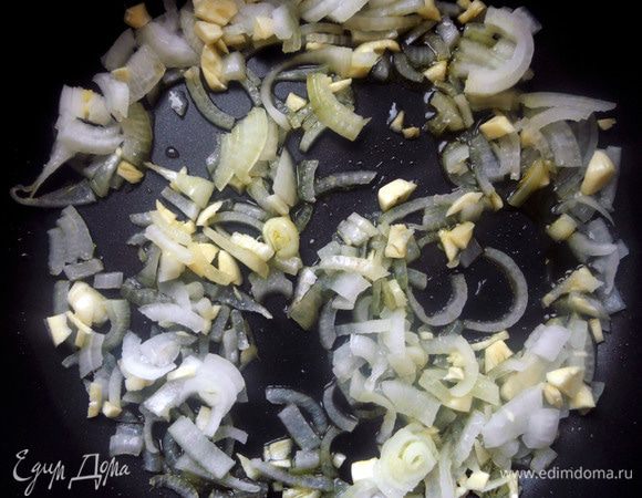 В глубокой сковороде разогреть немного оливкового масла, обжарить измельченные лук и чеснок, минут 5, до прозрачного состояния. Переложить в другую емкость. 