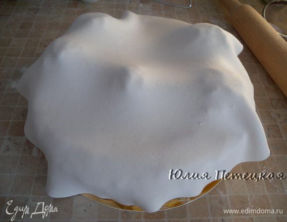 Приготовить белую маршмеллоу–мастику. Покрыть торт. Оставить на 5 минут, не трогая. Она сама примет форму бугров.