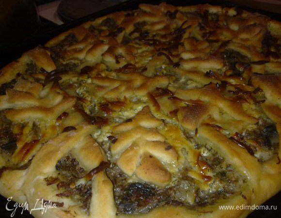 Тесто раскатать в круг,немного оставить для украшения,  выложить на него немного порезанного лука репчатого, затем распределить по поверхности мясо консервированное, грибы, украсить оставшимся тестом, сверху присыпать сыром и выпечь. 