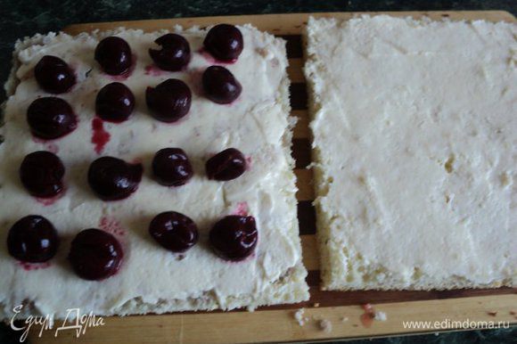 Белый бисквит разрезать на два пласта и пропитать коньяком, в котором настаивались вишни. Оба пласта смазать кремом, на один пласт выложить вишню, накрыть вторым пластом, стороной смазанной кремом.