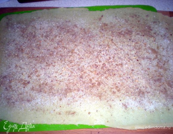 Тесто раскатать,посыпать сахаром,тертыми орехами и корицей.