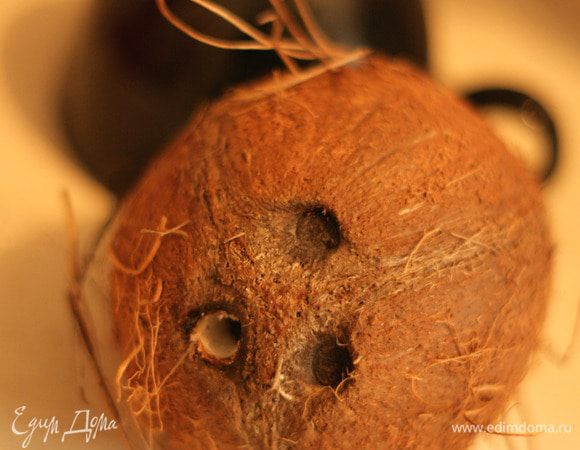 Сначала необходимо найти один из трех "глазков" кокоса имеющий вход внутрь. Остальные 2 закрыты наглухо, попасть через них вовнутрь возможно только с помощью дрели.
После того, как поддающийся глазок найден можно использовать тонкий нож или черенок ложки чтобы расширить отверстие.
Через него дать вытечь кокосовой воде. Она не будет нужна.
