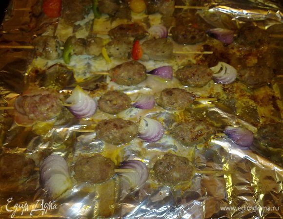 Из бараньего фарша формируем котлетки и насаживаем их на шпажки с красным луком. И в духовку до готовности.