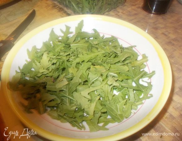 Руколу промыть обсушить порвать руками и выложить на тарелку или блюдо.