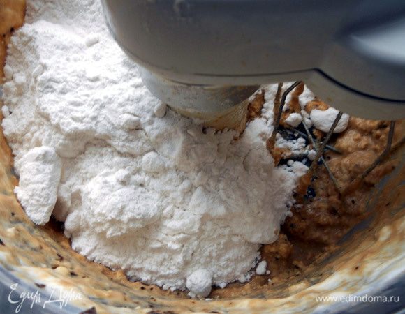 Присоединить сахарную пудру (в несколько этапов), очень хорошо размешать. Возможно потребуется не все количество, крем должен получится густым, по текстуре примерно как арахисовое масло или мягкая помадка. Растекаться не должен, но и с трудом распределяться тоже - что-то среднее. Сильно уменьшать количество пудры не рекомендую, иначе при подаче внешний вид, благодаря слишком мягкой сердцевине, пострадает. 