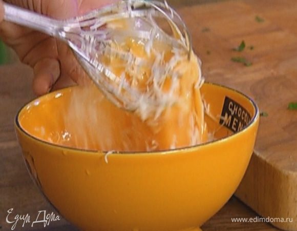 Яйца слегка взбить, посолить, поперчить, всыпать половину сыра и перемешать.