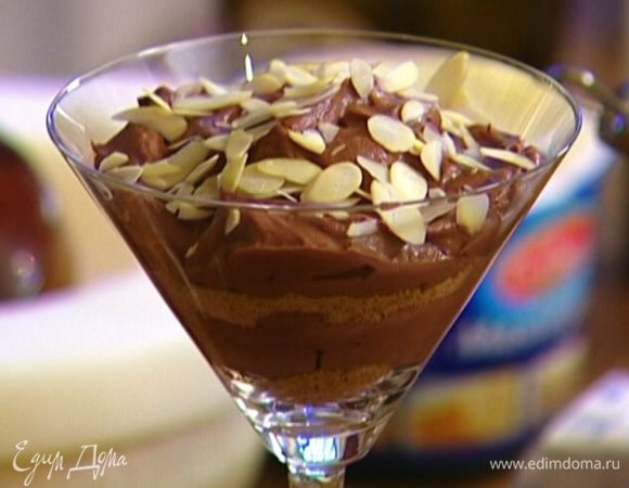 В глубокий бокал выложить 1 ч. ложку измельченного печенья, сверху 2 ч. ложки сырной массы, присыпать крошкой из печенья, а затем опять выложить несколько ложек сырной массы. Украсить мусс миндальными лепестками. 