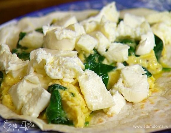 На одну половину тортильи выложить яйца со шпинатом, сверху кубики моцареллы и листья базилика, затем накрыть второй половиной лепешки, сложив ее пополам.