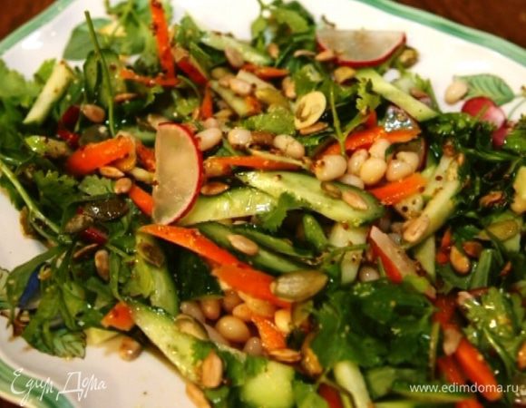 Полить салат заправкой и посыпать семечками.