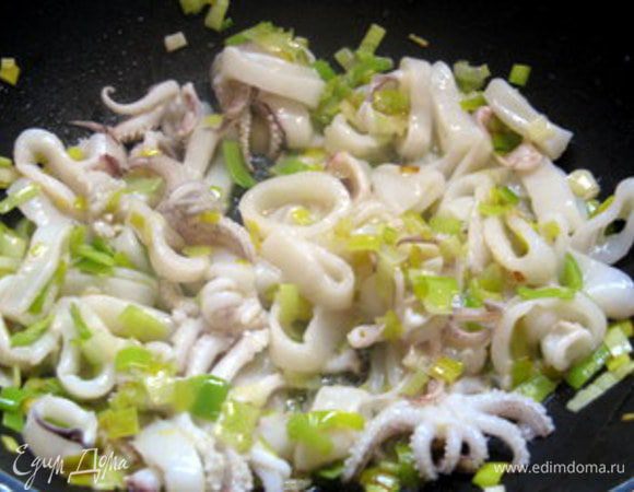 Добавить кальмары к луку и обжарить вместе пару минут.