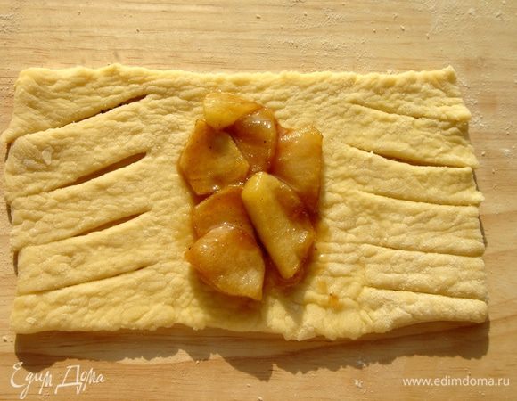 Тесто раскатать и разделить на прямоугольники 13х7 см. Края (по 4 см) надрезать под небольшим углом, а на середину (5 см) выложить по 1 ст. л. начинки.