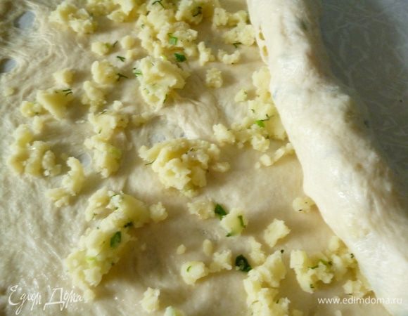 Корж слегка смазать растительным маслом. Распределяем начинку и аккуратно сворачиваем рулет и слегка растягиваем его.