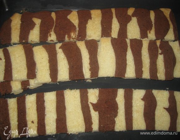 Выпекаем бисквит 15 минут в разогретой духовке при темп.180 градусов. Остужаем, освобождаем от бумаги. Нарезаем по ширине на полосы, равные периметру стенок  форм, в которых мы будем формировать пирожные.