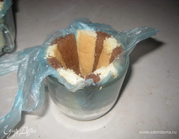 Формочки в которых будем выкладывать пирожные(приблиз. 250 мл в обьеме, у меня чашечки) застилаем пищевой пленкой. Выкладываем внутри формочек полоски бисквита.