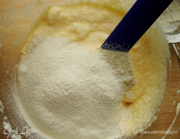В яичную массу небольшими порциями добавить просеянную муку. Тщательно перемешать,направляя лопатку (ложку) снизу вверх.