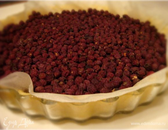 По истечении времени-достать тесто- раскатать на присыпанном мукой столе толщиной в 1 см. 
Духовку разогреть до 200 гр. ц.
Тесто уложить в форму плотно прижимая к ботам формы и ко дну. Сверху теста устелить пергаментную бумагу и насыпать доверху горох или фасоль.
