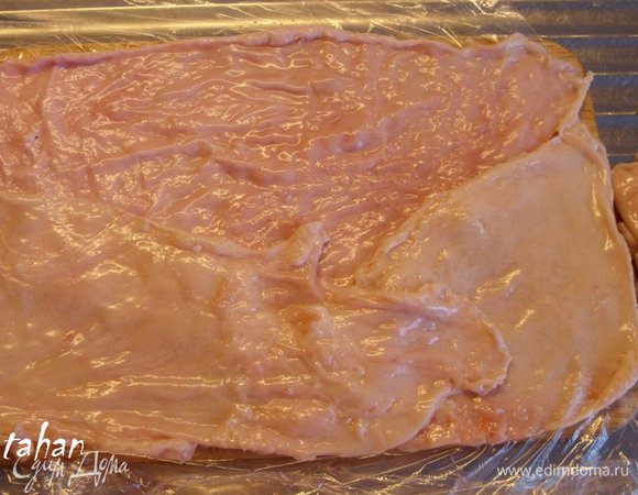 Разделочную доску застелить целлофановой плёнкой, а сверху разложить кожу немного внахлёст, так, что бы она закрывала всю поверхность  доски.