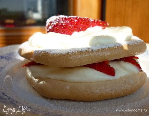 Собираем десерт:на одну половинку безе наносим сливки,посыпаем клубникой,накрываем другой безе,наносим сливки,кладём украшение из клубники,посыпаем сахарной пудрой.Приятного аппетита!!!