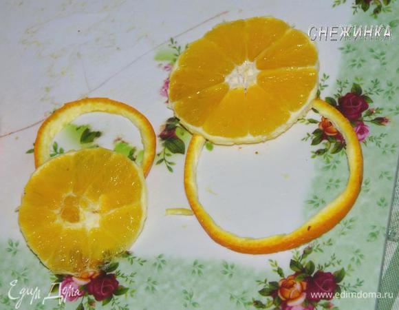 Для украшения используем половину апельсина и киви. Отрезаем два круга из апельсина, один больше, другой поменьше. Острым ножом отрезаем по окружности кожуру. 