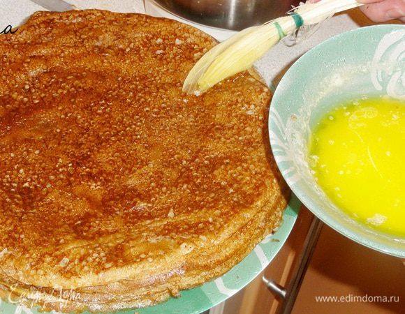 Затем снимаю и складываю на тарелку. Пока я смазываю блин растопленным сливочным маслом, блинница накаливается на плите.