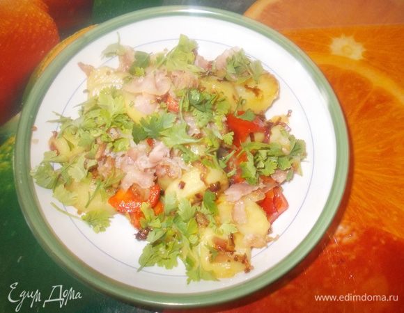 бекон нарезать небольшими ломтиками и обжарить в сковороде без масла,затем бекон вытащить и на этом жире обжарить мелко нарезанный лук,затем влить заправку довести до кипения и потомить на слабом огне пару минут,добавить варенный картофель,бекон,сладкий перчик нарезанный кубиками и помешать,потомить ещё пару минут.петрушку мелко нарезать и посыпать перед подачей.